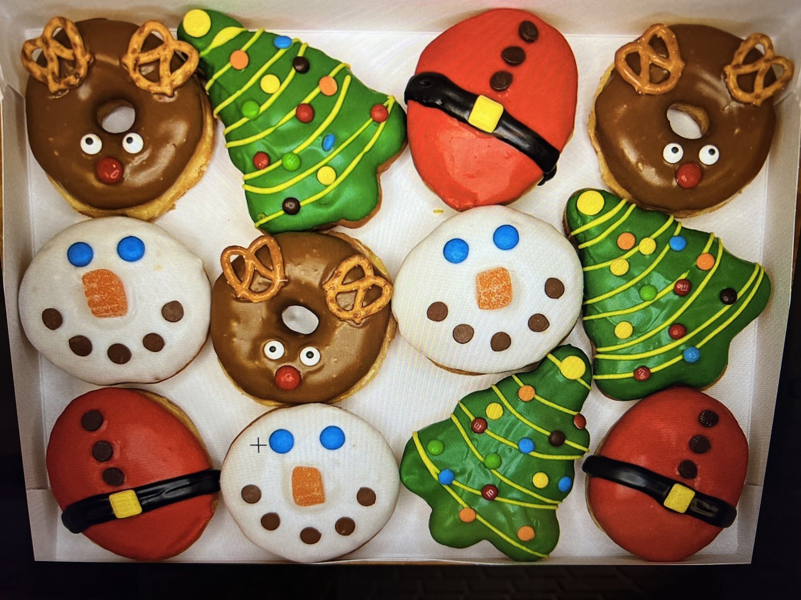 A Christmas box of decorated donuts — reindeer, snowmen and trees