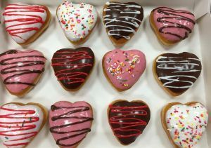 Heart-shaped donuts with icing drizzle, boxed