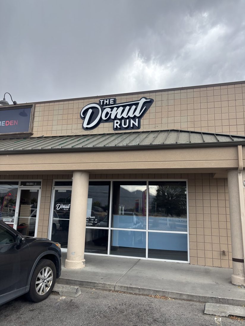 The Donut Run storefront, the sign above the door and the opening hours posted on the glass